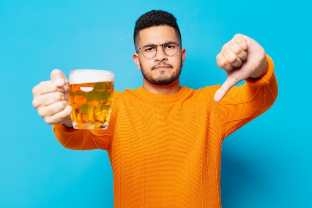 Young hispanic man sad expression and holding a beer