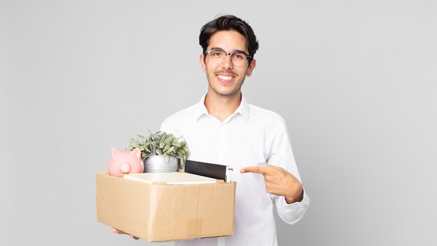 Young hispanic man smiling cheerfully, feeling happy and pointing to the side. dismissal concept