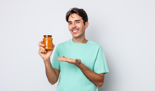 Young hispanic man smiling cheerfully, feeling happy and showing a concept. peach jelly concept