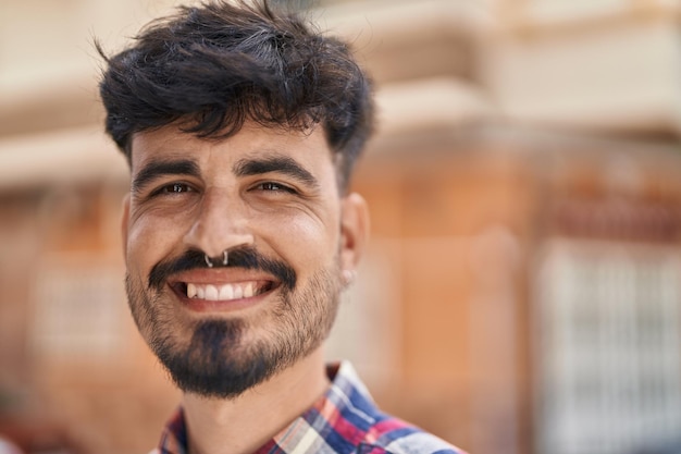 Young hispanic man smiling confident standing at street