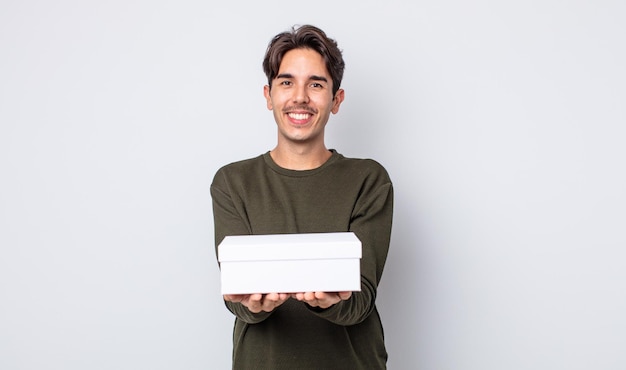 Young hispanic man smiling happily with friendly and  offering and showing a concept. white box concept