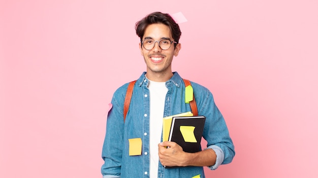 Young hispanic man smiling happily with a hand on hip and confident. student concept