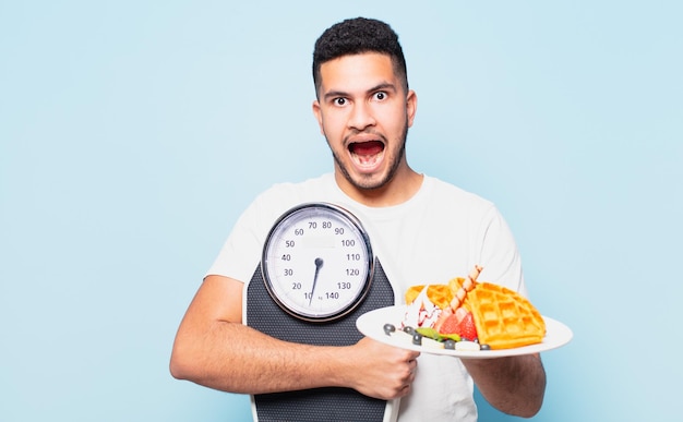 Young hispanic man surprised expression and dieting concept