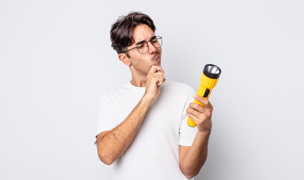 Young hispanic man thinking, feeling doubtful and confused. lantern concept