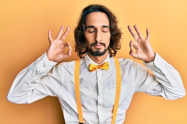 Photo young hispanic man wearing hipster elegant look relax and smiling with eyes closed doing meditation gesture with fingers yoga concept