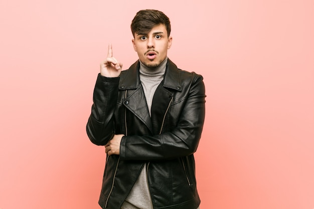 Young hispanic man wearing a leather jacket having some great idea, concept of creativity.