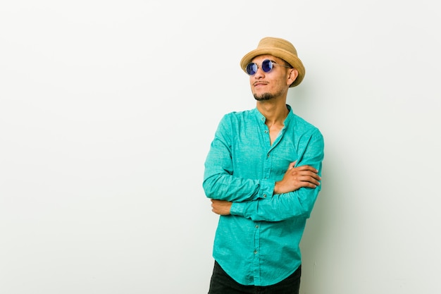 Young hispanic man wearing a summer clothes smiling confident with crossed arms.