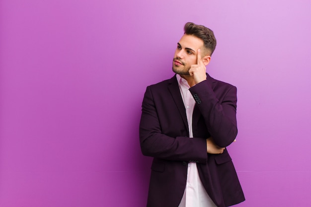 Young hispanic man with a concentrated look, wondering with a doubtful expression, looking up and to the side