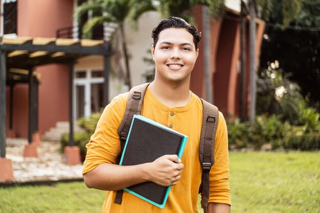 Young hispanic student smiling happy wearing a backpack at the university campus