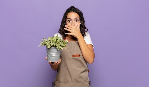 Young hispanic woman covering mouth with hands with a shocked, surprised expression, keeping a secret or saying oops