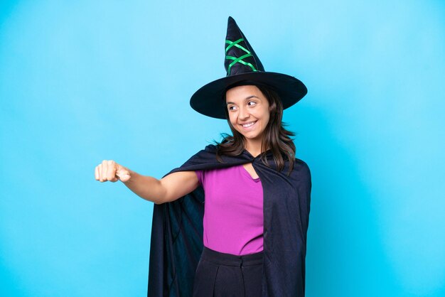 Young hispanic woman dressed as witch over isolated background giving a thumbs up gesture