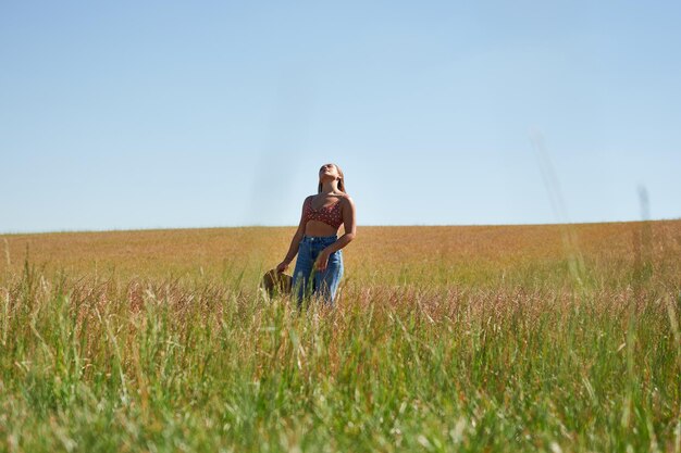 A young Hispanic woman enjoying the sun on a wheat field on a sunny day