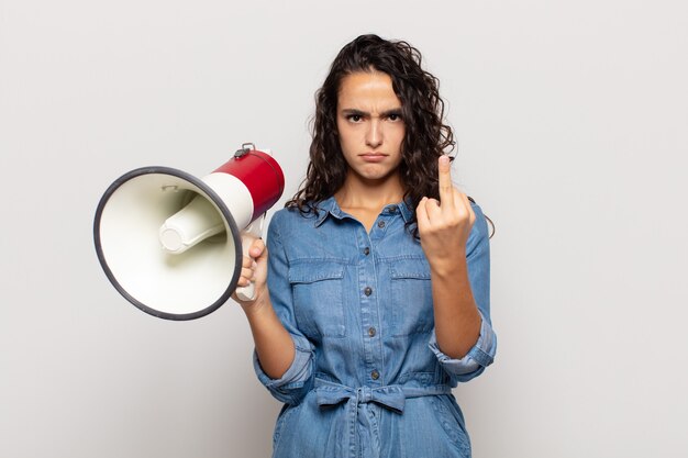 Foto giovane donna ispanica che si sente arrabbiata, infastidita, ribelle e aggressiva, lancia il dito medio, reagisce