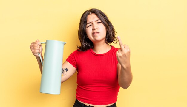 Young hispanic woman feeling angry, annoyed, rebellious and aggressive. thermos concept