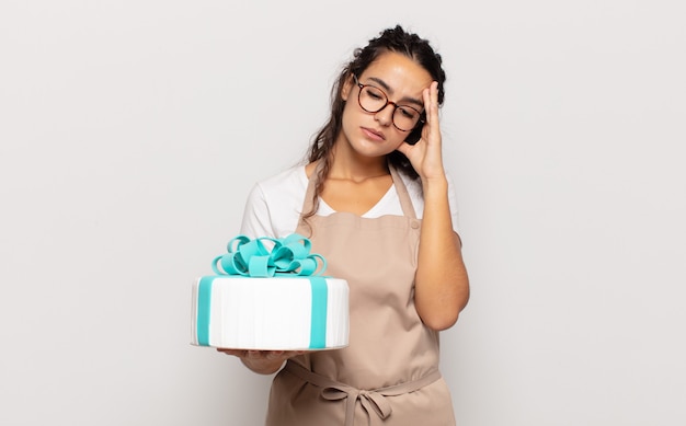 Young hispanic woman feeling bored, frustrated and sleepy after a tiresome, dull and tedious task, holding face with hand