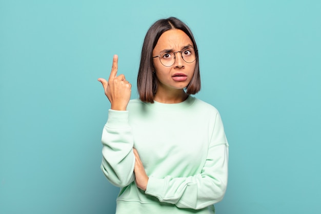 Young hispanic woman feeling confused and puzzled, showing you are insane, crazy or out of your mind