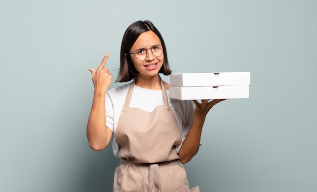 Young hispanic woman feeling confused and puzzled, showing you are insane, crazy or out of your mind