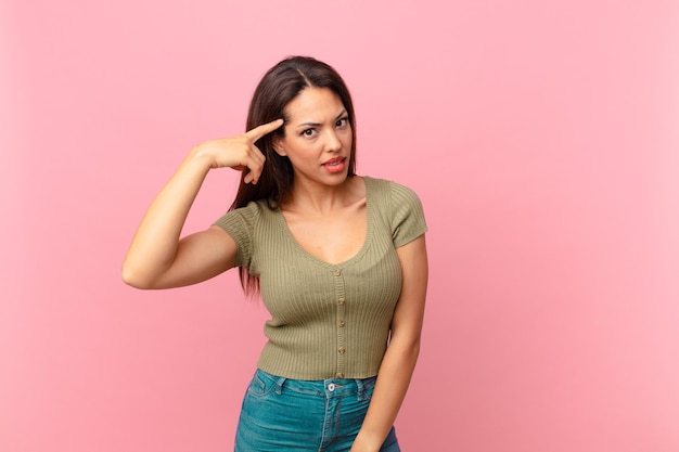 young hispanic woman feeling confused and puzzled, showing you are insane