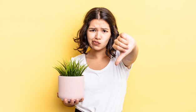 Young hispanic woman feeling cross,showing thumbs down. growth concept