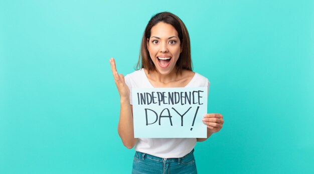 Young hispanic woman feeling happy and astonished at something unbelievable. independence day concept