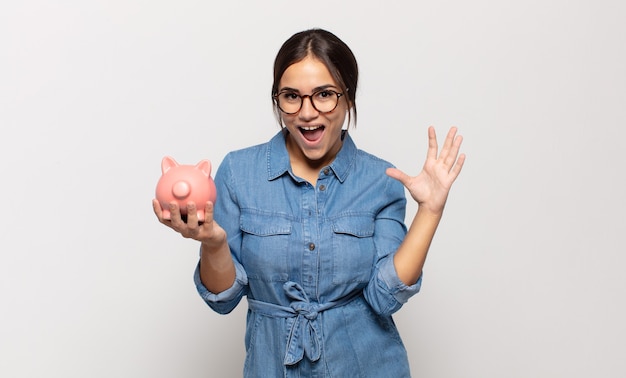 Young hispanic woman feeling happy, excited, surprised or shocked, smiling and astonished at something unbelievable