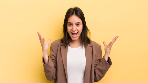 Young hispanic woman feeling happy excited surprised or shocked smiling and astonished at something unbelievable