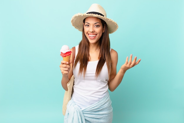 Young hispanic woman feeling happy, surprised realizing a solution or idea and holding an ice cream. sumer concept