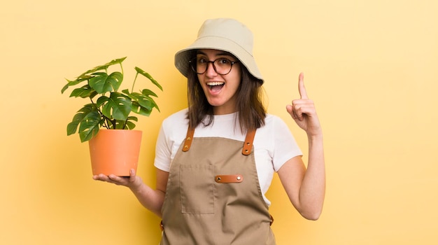 Молодая латиноамериканка чувствует себя счастливым и взволнованным гением после реализации идеи садовника и концепции растений