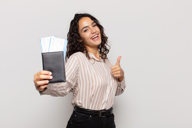 Young hispanic woman feeling proud, carefree, confident and happy, smiling positively with thumbs up