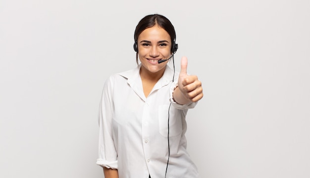 Young hispanic woman feeling proud, carefree, confident and happy, smiling positively with thumbs up