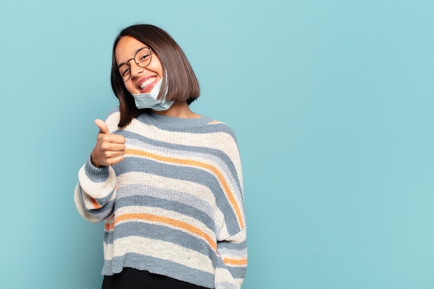 Young hispanic woman feeling proud, carefree, confident and happy, smiling positively with thumbs up