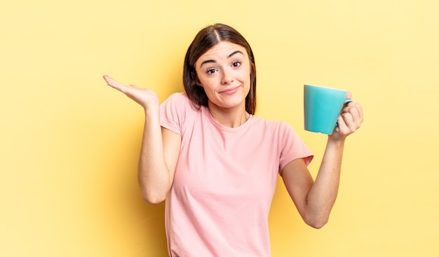 Young hispanic woman feeling puzzled and confused and doubting. coffee cup concept