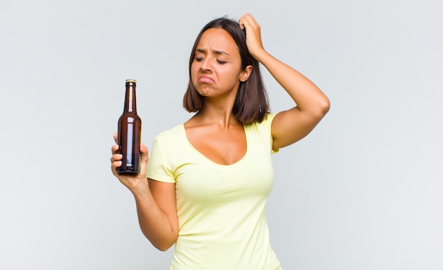 Young hispanic woman feeling puzzled and confused, scratching head and looking to the side