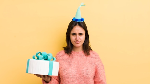 Young hispanic woman feeling sad upset or angry and looking to the side birthday concept