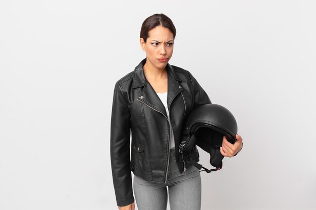 Young hispanic woman feeling sad, upset or angry and looking to the side. motorbike rider concept