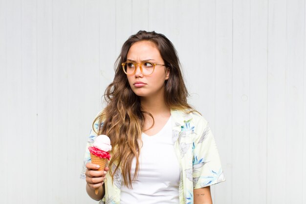 Young hispanic woman feeling sad, upset or angry and looking to the side with a negative attitude, frowning in disagreement