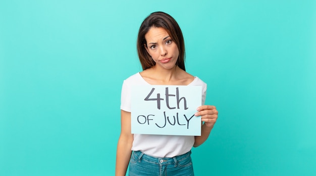 Young hispanic woman feeling sad and whiney with an unhappy look and crying. independence day concept