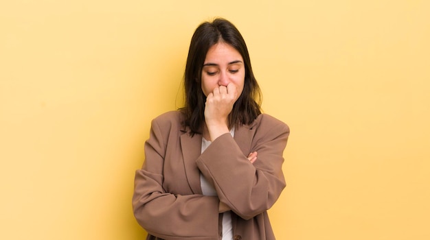 Young hispanic woman feeling serious thoughtful and concerned staring sideways with hand pressed against chin