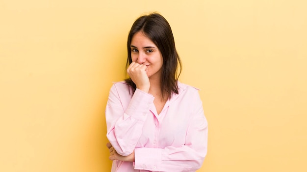 Young hispanic woman feeling serious thoughtful and concerned staring sideways with hand pressed against chin