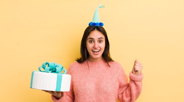 Young hispanic woman feeling shockedlaughing and celebrating success birthday concept