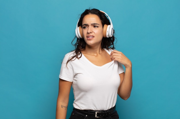 Young hispanic woman feeling stressed, anxious, tired and frustrated, pulling shirt neck, looking frustrated with problem