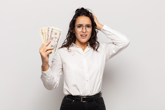 Young hispanic woman feeling stressed, worried, anxious or scared, with hands on head, panicking at mistake