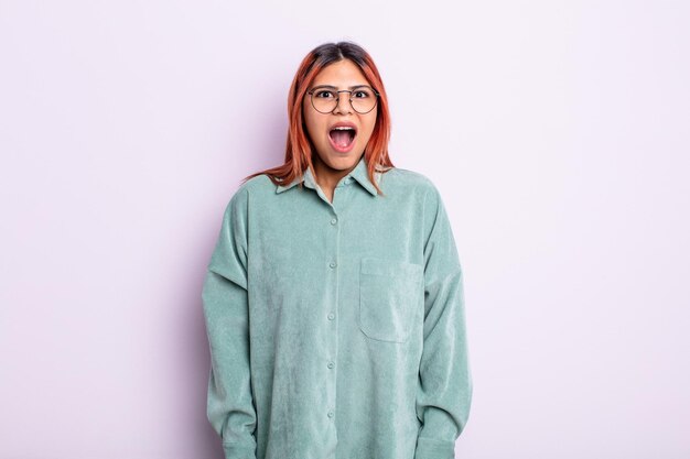 Young hispanic woman feeling terrified and shocked with mouth wide open in surprise