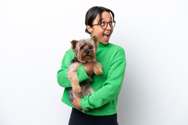 Young hispanic woman holding a dog isolated on white background intending to realizes the solution while lifting a finger up