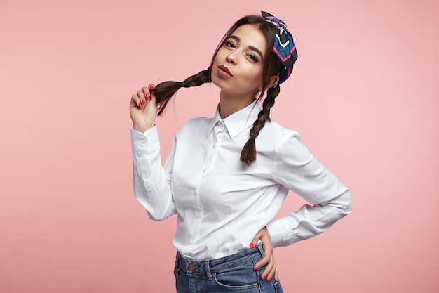 Young hispanic woman holding her ponytail