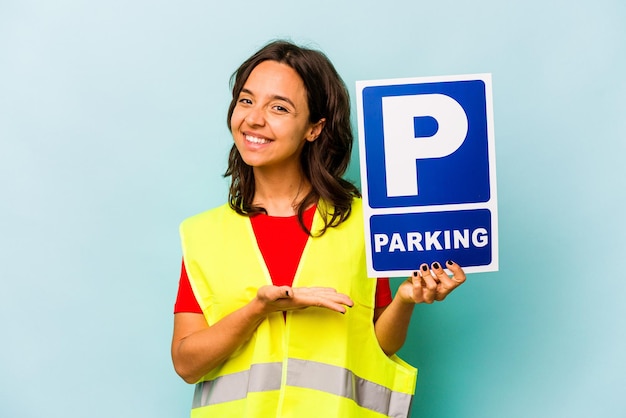 Foto giovane donna ispanica con cartello di parcheggio isolato su sfondo blu