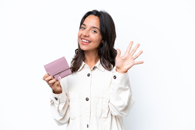 Young hispanic woman holding wallet isolated on white background counting five with fingers