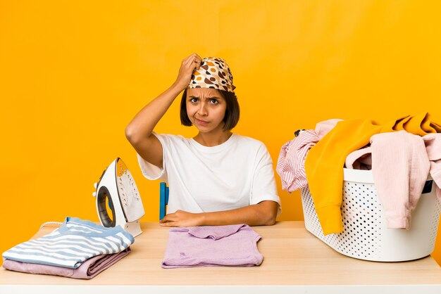 Young hispanic woman ironing clothes isolated being shocked, she has remembered important meeting.