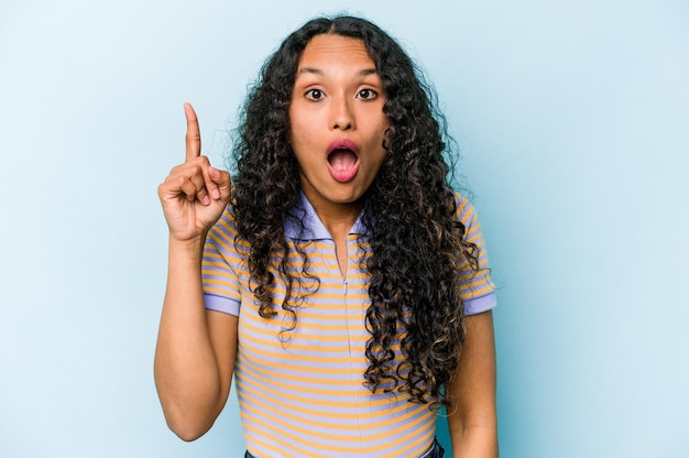 Young hispanic woman isolated on blue background having some great idea concept of creativity