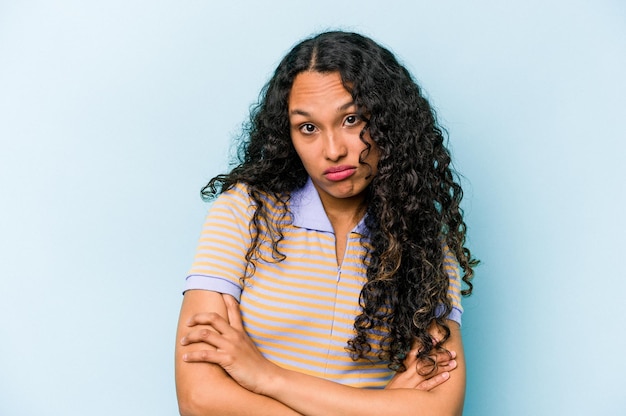 Young hispanic woman isolated on blue background who is bored fatigued and need a relax day